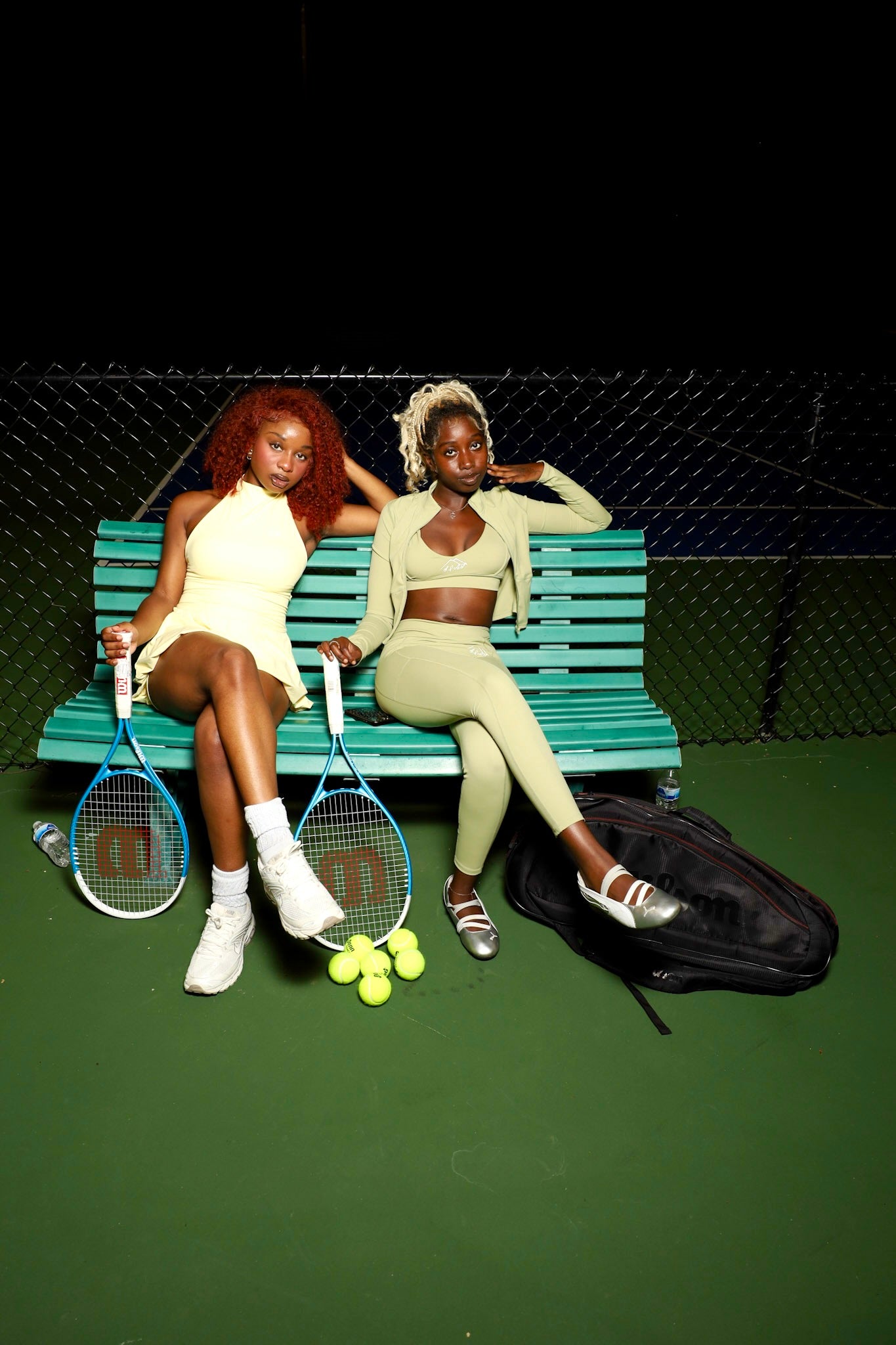 S.I.A.F HAUS models on a tennis court bench representing the Hausmate Pass membership.